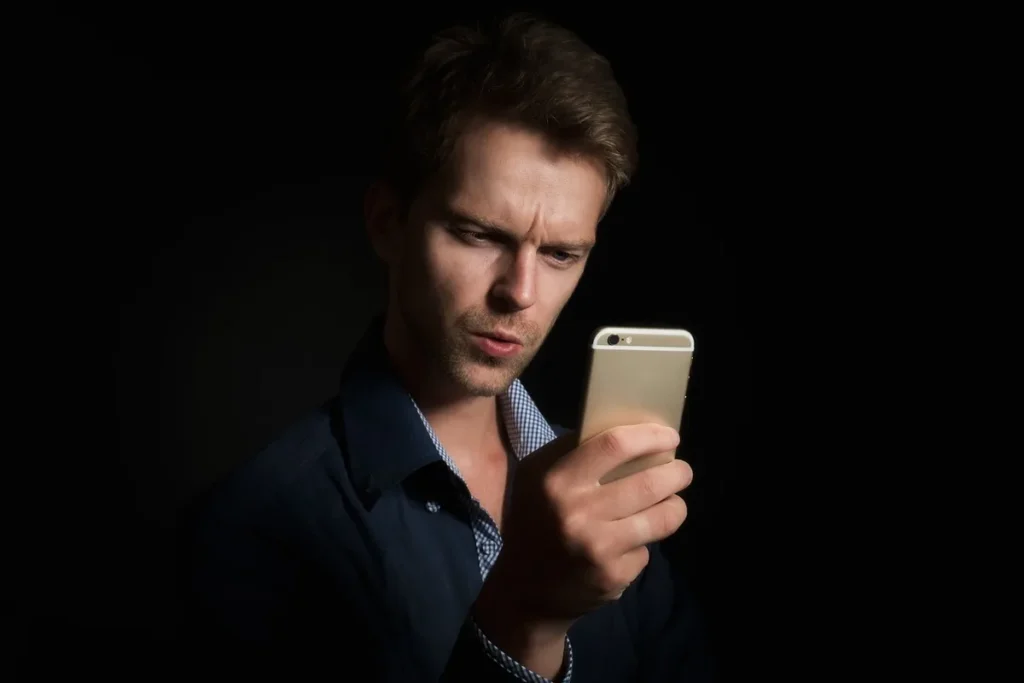 Mity żywieniowe w sieci: mężczyzna z niedowierzaniem czyta poradę dietetyczną w telefonie